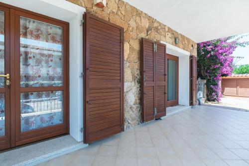 ein Paar Holztüren an der Seite eines Hauses in der Unterkunft Bilo Corallo 2 Palau in Palau