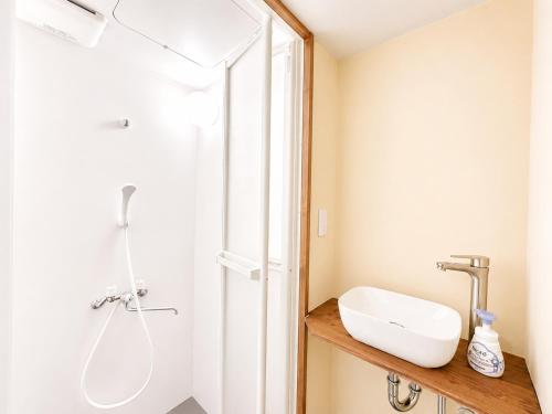 a bathroom with a sink and a shower at 結莉の宿 高槻 in Takatsuki