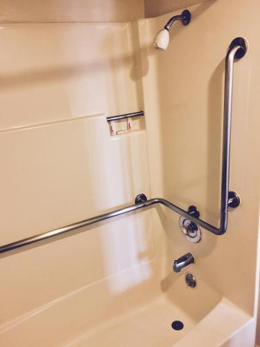 a shower with a hand rail in a bathroom at Travelodge by Wyndham Reno in Reno
