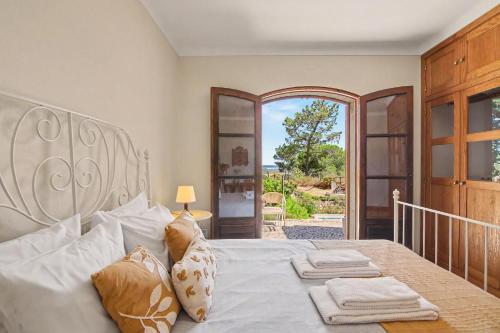 a bedroom with a large bed with towels on it at Casa Do Cerro in Luz de Tavira