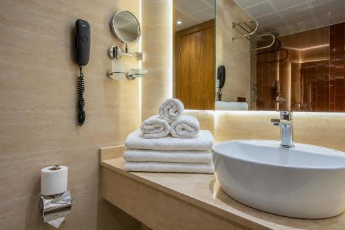 a bathroom with a sink and a phone and towels at World Star Beach Resort & Spa in Alanya