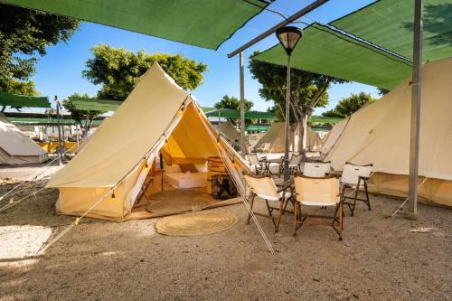 a group of tents with chairs and a table at Kampaoh Roquetas in Roquetas de Mar
