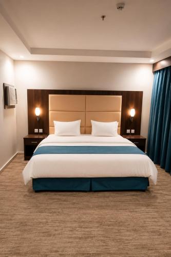 a large bedroom with a large bed with two night stands at Hmm Serviced Apartments in Al Kura