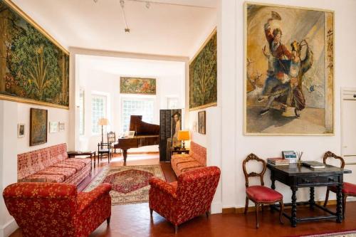 a living room with red furniture and a painting on the wall at Hotel Club I Pini - Boutique Hotel & Residenza d'Epoca in Lido di Camaiore