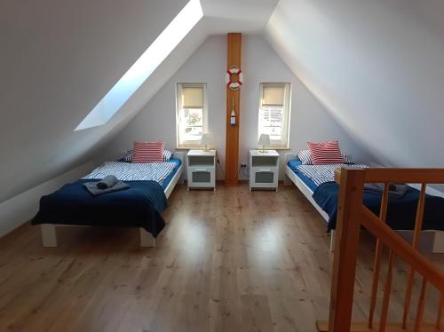a attic room with two beds and a staircase at Baltic Sea in Jastarnia