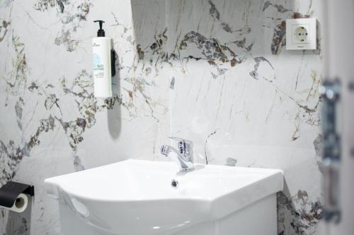 a bathroom with a white sink and a white wall at Motel Nova in Strumica