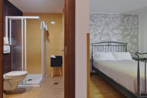 a bedroom with a bed and a shower and a toilet at Pensión Casa Felisa in Monforte de Lemos