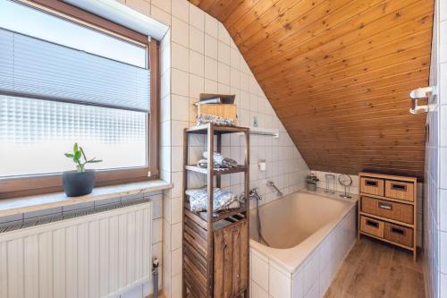 a bathroom with a large tub and a window at Bassd scho in Ebensfeld