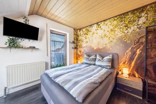 a bedroom with a bed and a tv on a wall at Bassd scho in Ebensfeld