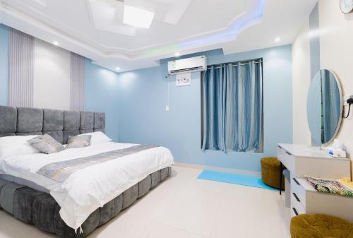 a blue bedroom with a bed and a mirror at شقه الاطلال in Jeddah