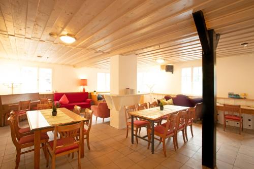 a restaurant with tables and chairs and a couch at Westküste Lindau in Lindau