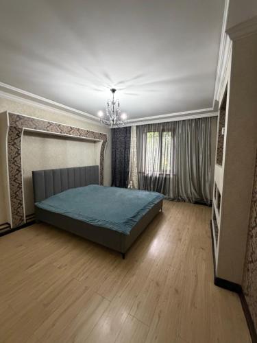 a bedroom with a bed in the middle of a room at 3 комнатные апартаменты in Karagandy