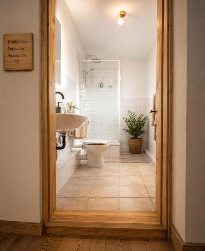 a bathroom with a sink and a toilet and a tub at Hotel Restaurant Kommodich in Kellinghusen