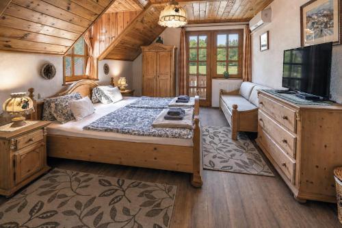 a bedroom with a large bed and a tv at Hanga Vendégház Parád in Parád