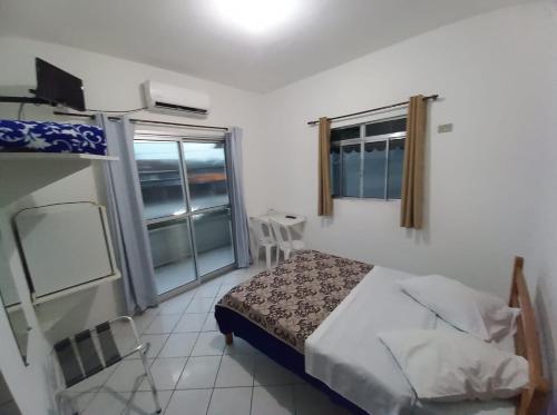 a small bedroom with a bed and a window at HOTEL MORADA DO SOL in Pontal do Paraná