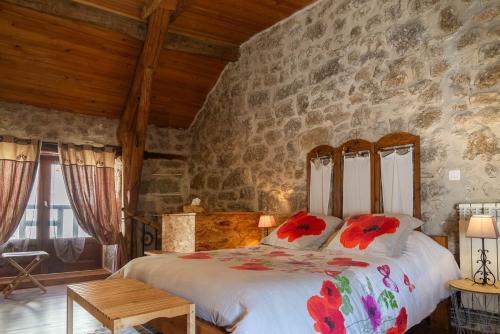 a bedroom with a bed and a stone wall at L'echappée de la lozère in Les Laubies