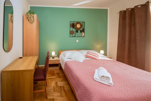 a bedroom with a bed with a pink bedspread at Guest Accommodation Slapovi Krke in Lozovac