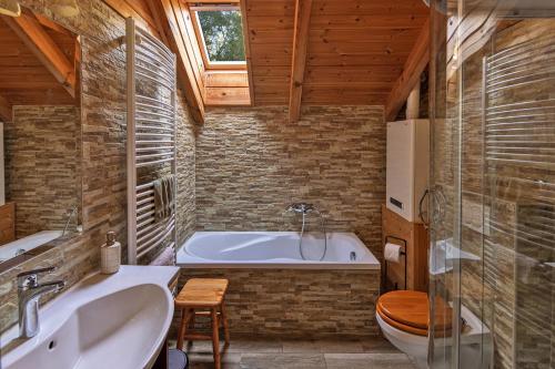 a bathroom with a tub and a toilet and a sink at Hanga Vendégház Parád in Parád