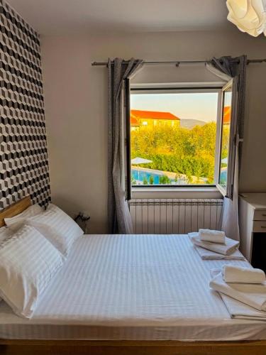 a bedroom with a large bed and a window at Vila CarpeDiem in Herceg-Novi