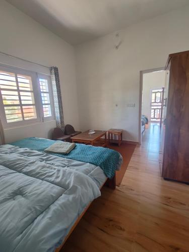 a bedroom with a large bed and a wooden floor at MP Residency Homestay in Munsyari