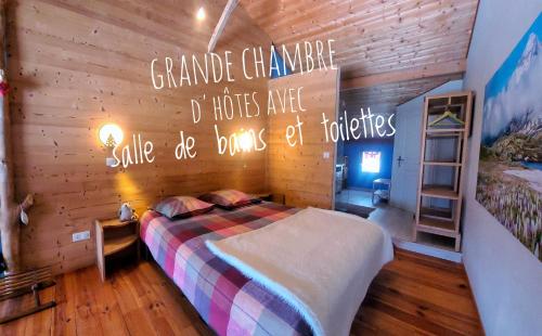a bedroom with a bed and a sign on the wall at Chambre d'hôtes à la Chèvrerie de Saint Michel in Beaune
