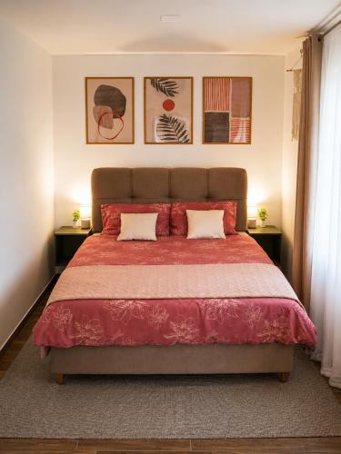 a bedroom with a large red bed with two pillows at Vila Atlantida in Velika