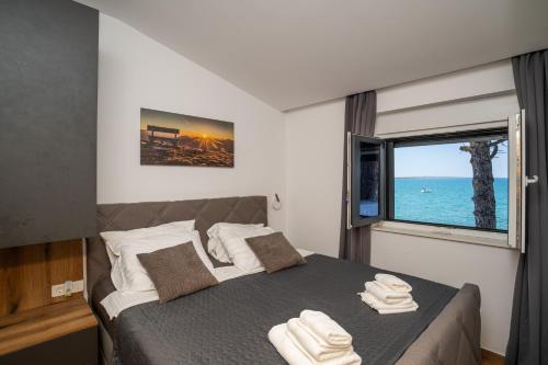 a bedroom with a bed with a large window at Villa Borik in Vrsi
