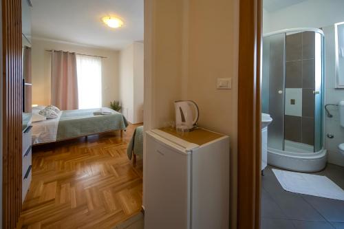 a room with a bathroom with a bed and a refrigerator at Guest Accommodation Slapovi Krke in Lozovac