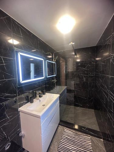 a bathroom with a sink and a tv on the wall at Сузірʼя in Vorokhta