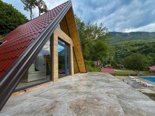 a house with a red roof and a large patio at Rafting Center "TARA-RAFT" in Bastasi