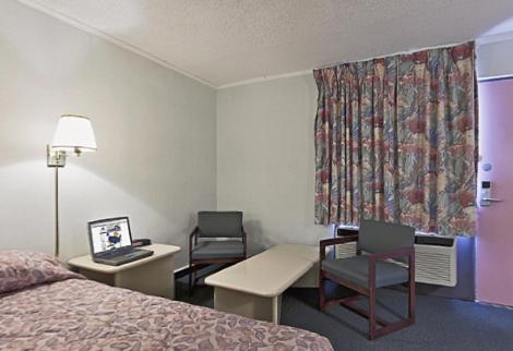 BishopvilleにあるAmericas Best Value Inn - Bishopvilleのベッド、デスク、椅子が備わるホテルルームです。