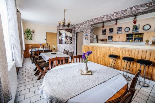 a dining room with a table and chairs and a bar at Stáj Newport in Dolní Domaslavice