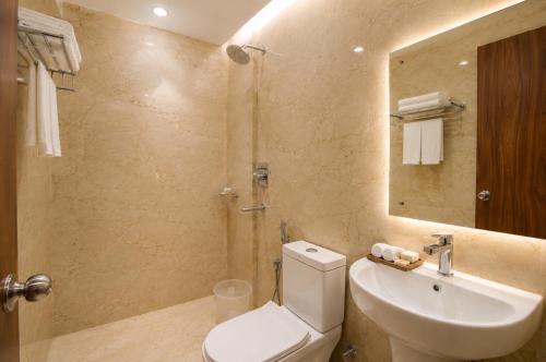 a bathroom with a toilet and a sink and a mirror at Namastey Puri Hotel - Near Jagannath Dham Temple With Restaurant And Parking Facility Fully Air Conditioning Room in Puri