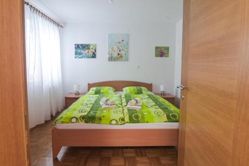 a bedroom with a bed with a green comforter at Počitniško stanovanje Aurora in Bovec