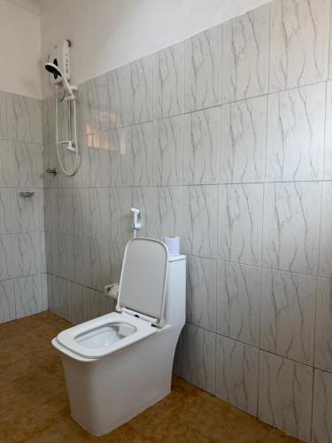 a white toilet in a bathroom with a shower at Amora Homestay and Safaris in Karatu