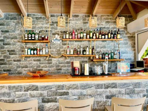 a bar with a stone wall and some bottles at Achillion Hotel in Skala Potamias