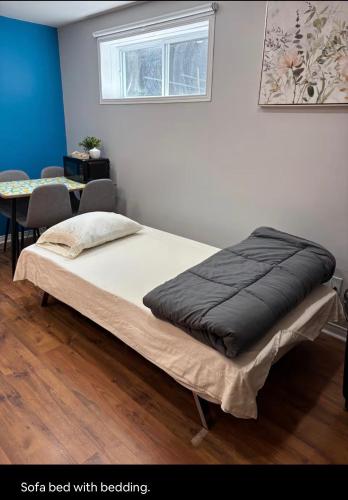 a bed in a room with a table and a window at Private apartment-separate in Pincourt