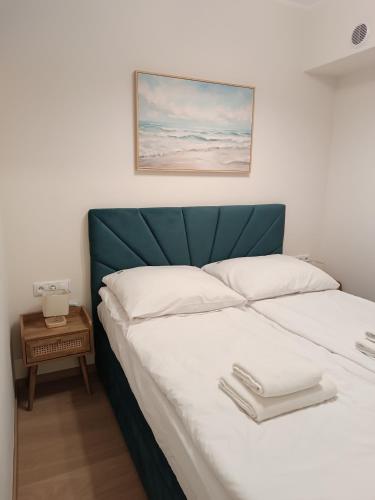a bedroom with a bed with a green headboard at Apartament 512 in Dziwnówek