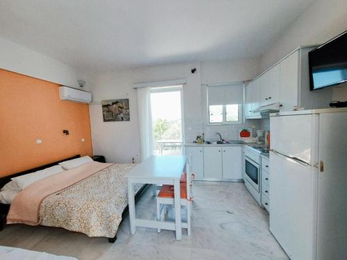 a small kitchen with a bed and a table in a room at Areti & Maria Apartments in Gythio