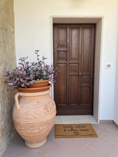 a large vase with a plant in front of a door at Casa Manu in Gallipoli