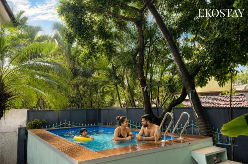 a group of people sitting in a swimming pool at EKOSTAY - Copacabana Villa in North goa