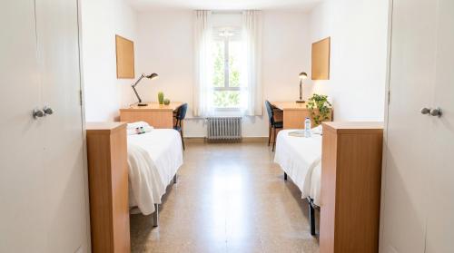 a hospital room with two beds and a window at Residencia Universitaria Resa Sant Jordi in Tarragona