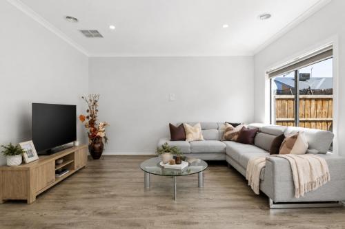 a living room with a couch and a tv at Sara by Ready Set Stay in Caroline Springs