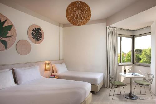a hotel room with two beds and a window at UNA Hotels Forte Dei Marmi in Forte dei Marmi