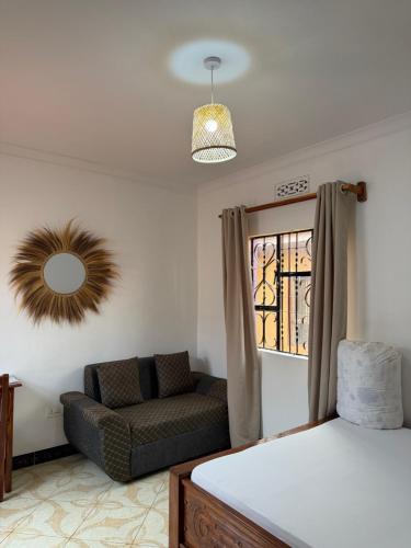 a bedroom with a bed and a chair and a mirror at Amora Homestay and Safaris in Karatu