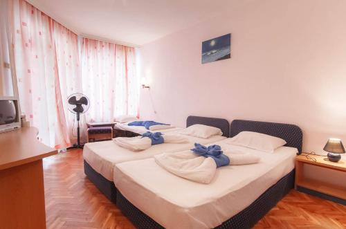 a bedroom with two beds with blue bows on them at Къща за гости ДИАМАНТ in Primorsko