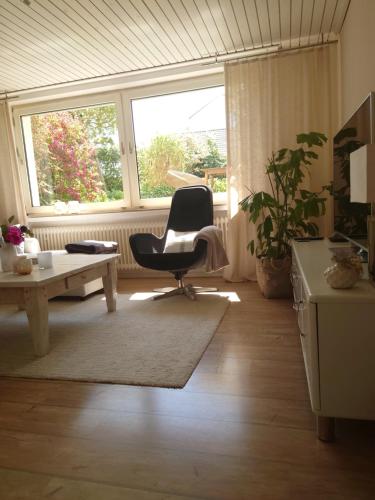 a living room with a chair and a table at Ferien am See in Möhnesee