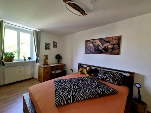 a bedroom with a bed with a zebra printed sheets at Henneberger Hof Wildlife in Münnerstadt