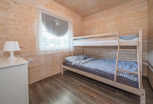 a bedroom with bunk beds in a wooden cabin at Domki PoZdrowie in Rusinowo
