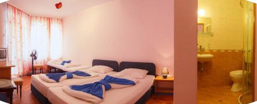 a bedroom with two beds with blue towels on them at Къща за гости ДИАМАНТ in Primorsko